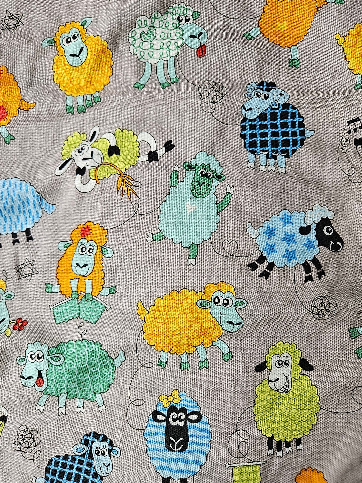 Fun Colourful Sheep's Handmade Blanket on Grey background. Double sided, cotton fabric in one side, and bright fluorescent green fleece at the back.