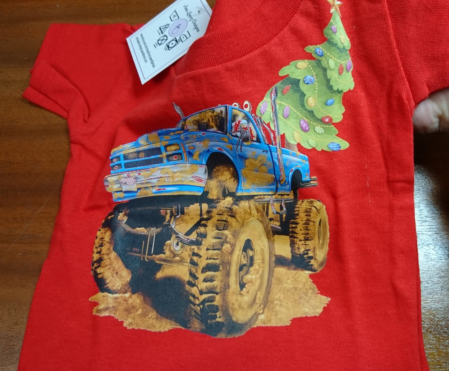 T-Shirts with the print of The Muddy Monster Truck carrying a Christmas Tree. Comfortable, soft Tees for Toddlers, Youth and Adults.