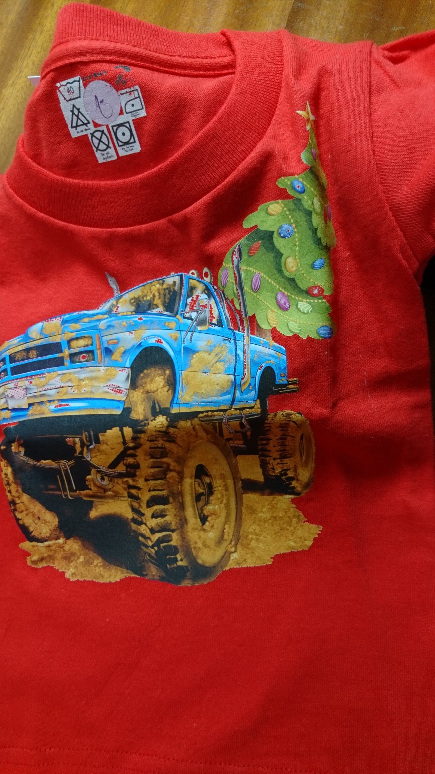 T-Shirts with the print of The Muddy Monster Truck carrying a Christmas Tree. Comfortable, soft Tees for Toddlers, Youth and Adults.